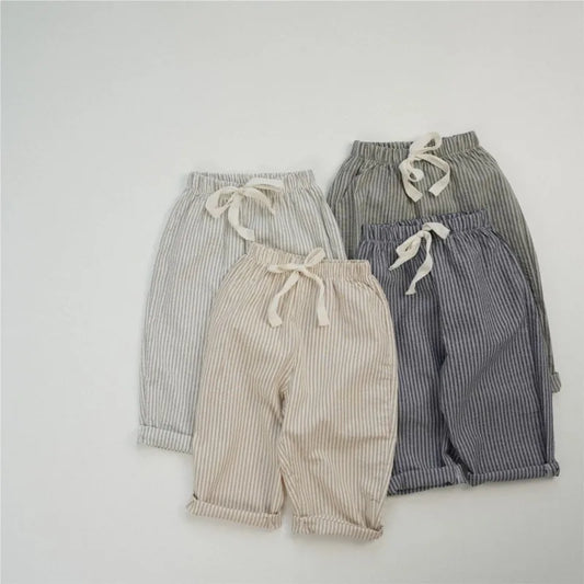 Four pairs of striped pants in beige, gray, and blue on a light gray background