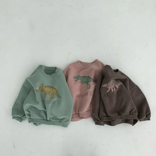 Three children's sweatshirts with dinosaur designs on a light gray background